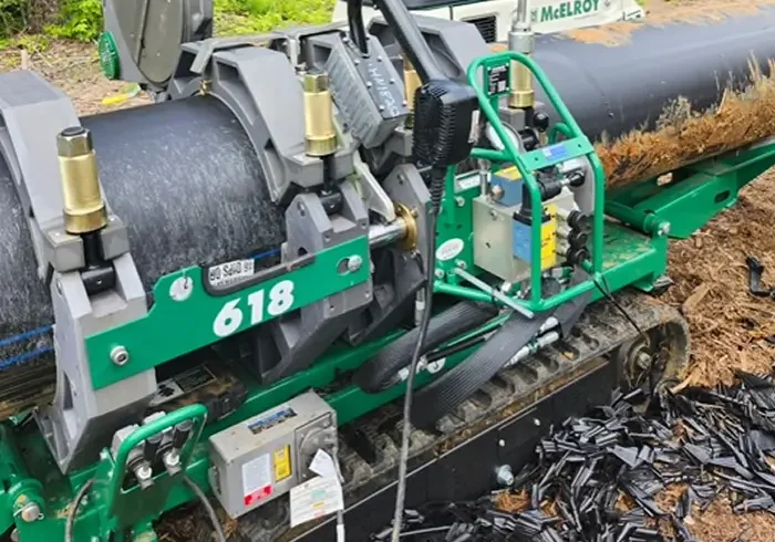 Close-up of machinery with hydraulic components and a green frame.